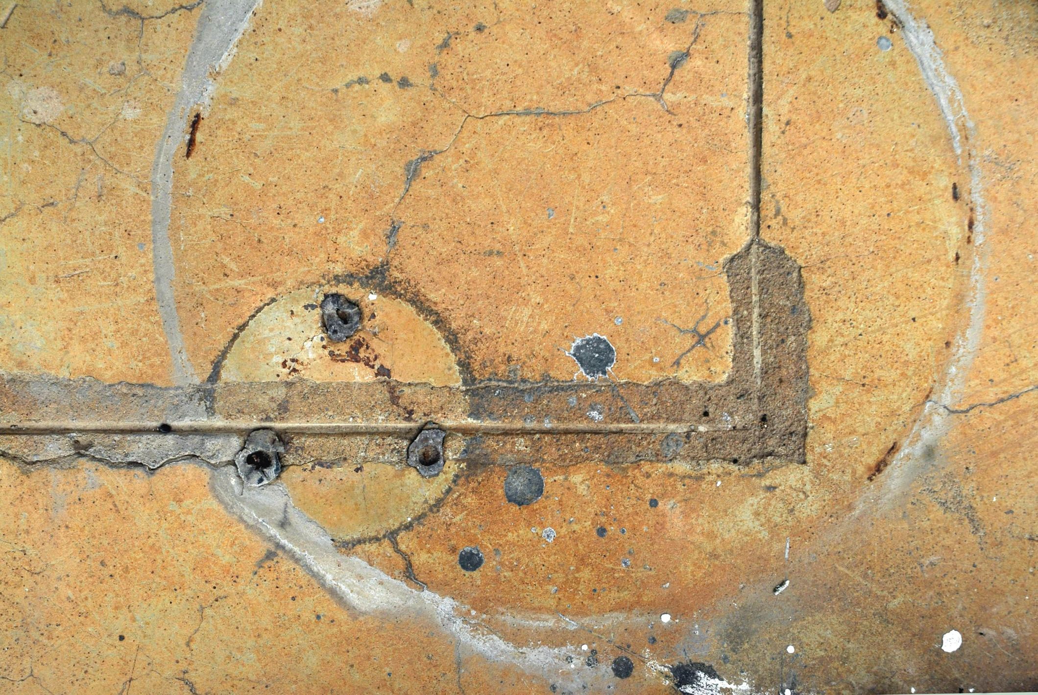 Weathered concrete surface with metal fixtures — abstract texture